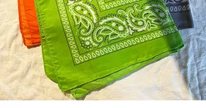 Détail de bandanas paisley colorés en vert néon, orange et gris sur tissu blanc