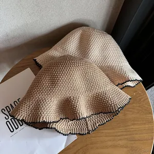 Gebreide vissershoed met contrasterende zwarte rand in beige en crème