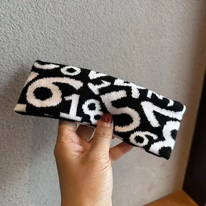 Close-up of knitted sports headband featuring black and white jacquard number patterns