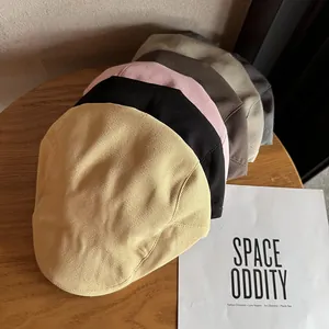 Classic cotton beret and ivy cap in multiple colors shown on a rustic wooden surface