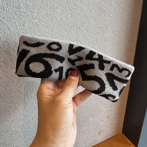 Detail of grey knitted sports headband with black jacquard number patterns for fitness