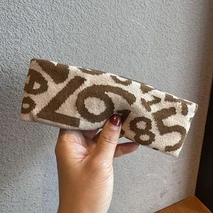 Macro detail of knitted sports headband featuring brown number patterns on beige fabric