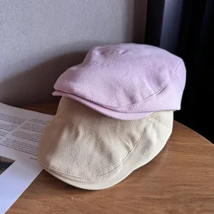 Vintage lavender and beige flat caps on a wooden table with soft aesthetic lighting
