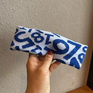 Detailed view of blue and white knitted sports headband with jacquard numeric pattern