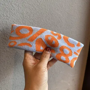Detail of high-density knitted sports headband with gray and orange jacquard number pattern