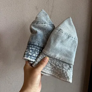 Handheld view of vintage washed denim bucket hats in dark and light blue cotton fabric