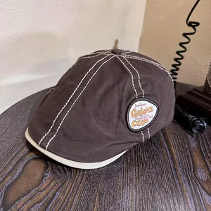 Close-up of brown vintage flat cap with contrast stitching and Gsior's CUP embroidery