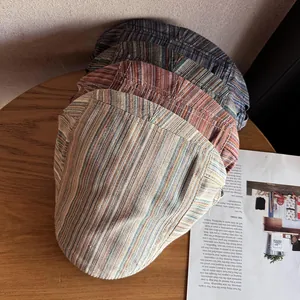 Berretti a righe vintage stile britannico impilati su una scrivania in legno retrò