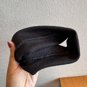 Nahaufnahme der inneren Nähte und der hochwertigen Strickstruktur des schwarzen Stirnbands