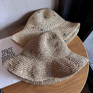 Deux chapeaux de paille à larges bords avec broderies d'étoiles colorées sur bois