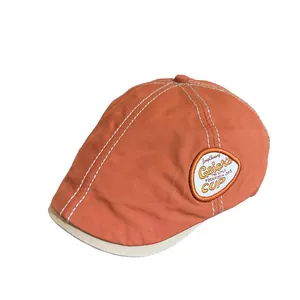 Retro orange and beige newsboy cap with white stitching and embroidered emblem