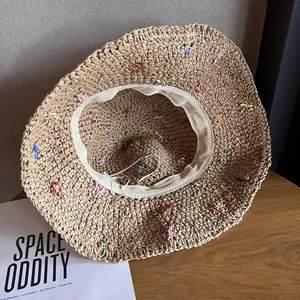 Gros plan d'un chapeau de paille fait main avec broderies colorées et texture crochet