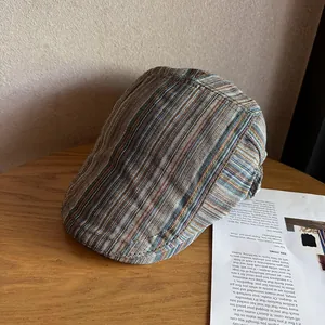 Dettaglio di un cappello piatto vintage a righe con texture di tessuto su legno