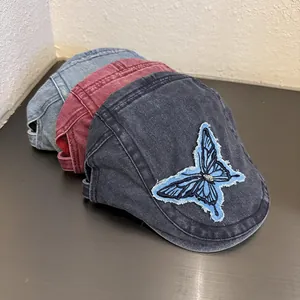 Three vintage denim newsboy caps in light blue, wine red, and grey with butterfly embroidery