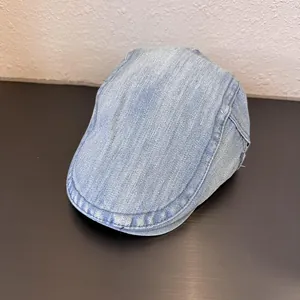 Detailed view of light blue washed denim flat cap with reinforced double stitching