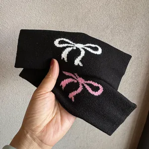 Gestrickte elastische Haarbänder in Schwarz mit weißen und rosa Schleifenmustern im Set