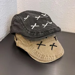 Detail of denim newsboy caps with ribbon bows in dark grey and khaki color options