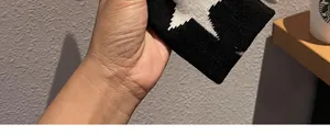 Close-up of a black and white knitted star pattern headband with clear woven texture