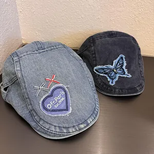 Top view of vintage denim beret hats featuring heart and butterfly embroidery patches