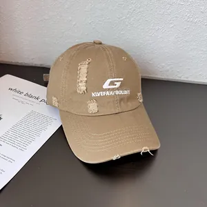 Close-up of distressed khaki canvas baseball cap with white letter G embroidery