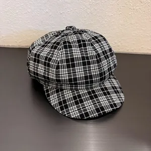 Detail of classic black and white plaid newsboy cap showing texture and fine stitching