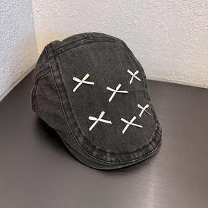 Detail of dark gray washed denim beret with six white ribbon bows and neat stitching