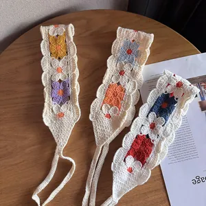 Three handmade colorful crochet floral headbands on a wooden table with rustic style