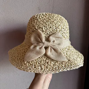 Close-up of beige woven straw hat featuring a breathable texture and large bow decoration