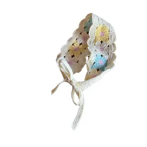 Handmade crochet floral headband with colorful flowers and wavy edges on ivory base