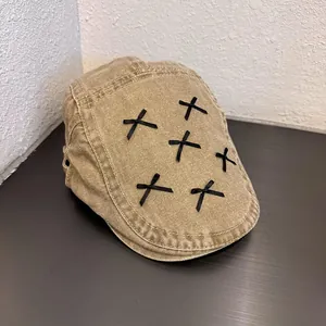Detail of khaki cotton newsboy cap featuring black ribbon bow decorations and stitching