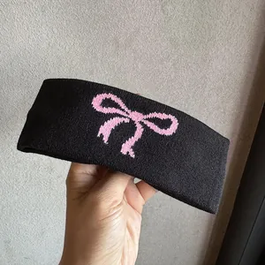 Details des schwarzen Strickstirnbands mit rosa Schleife und weicher elastischer Textur
