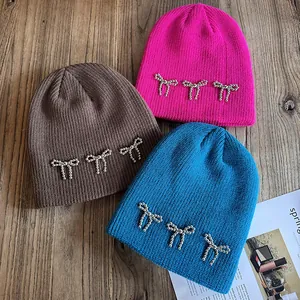 Bonnets en maille chic avec nœuds en perles métalliques en rose, marron et bleu paon