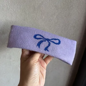 Detail der Textur eines lila elastischen Strick-Stirnbands mit blauem Schleifendesign