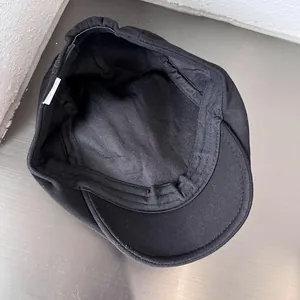 Classic black newsboy cap with adjustable inner strap and premium cotton fabric texture