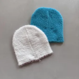 Nahaufnahme der beigen und blauen Strickmützen aus Pelzimitat mit flauschiger Textur