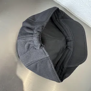 Detail view of black newsboy hat featuring elastic back adjustment and soft inner lining