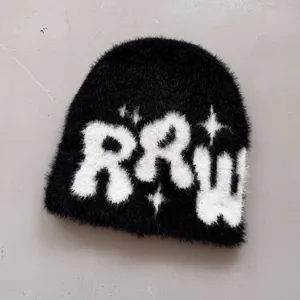 Detail einer schwarzen Plüsch-Strickmütze mit weißen RRW-Buchstaben und Sternmuster