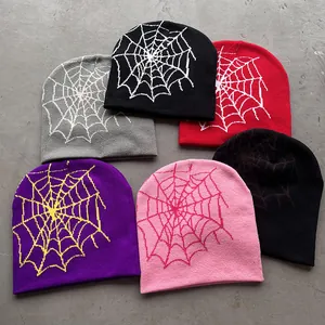 Gebreide mutsen met spinnenwebmotieven in de kleuren grijs, zwart, rood en paars