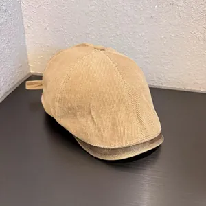 Detail view of khaki corduroy fabric and vintage leather brim on the flat cap