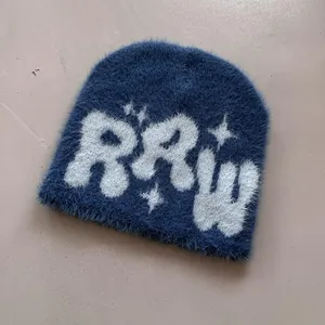 Detailaufnahme der blauen Kunstpelz-Strickmütze mit weißem RRW-Jacquard-Muster für Damen