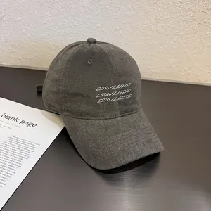 Détail d'une casquette de baseball en velours gris avec broderie sur un bureau
