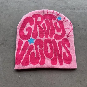 Detail van roze gebreide muts met jacquardbelettering en een blauw sterpatroon