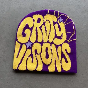Detail van paarse gebreide muts met gele jacquard letters en spinnenweb-ontwerp