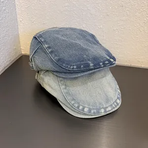 Dettaglio macro di berretti newsboy in denim vintage con texture lavate blu scuro e chiaro