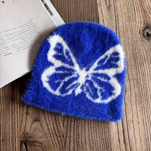Nahaufnahme einer flauschigen königsblauen Beanie mit weißem Schmetterlingsmuster