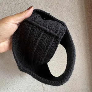 Detailansicht der dicken schwarzen Strickstruktur und des handgemachten Wellenmusters