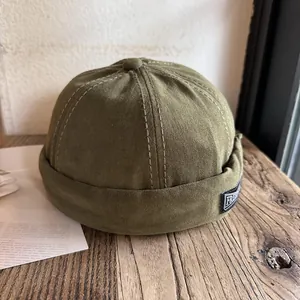 Detailed top view of army green cotton dock captain hat with white reinforced stitching
