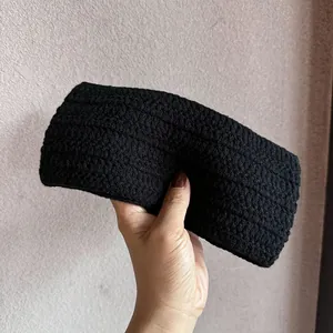 Nahaufnahme des schwarzen Strickstirnbands mit handgefertigter Häkelstruktur und breitem Design