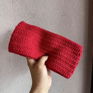 Nahaufnahme des handgestrickten roten Stirnbands mit dicker Wollwebstruktur