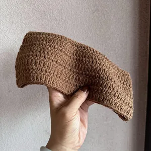 Detailansicht eines handgestrickten braunen Stirnbands mit dicker Wolltextur